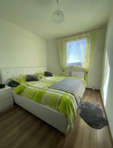 斯维特Svit apartment High Tatras的一间卧室设有一张大床和一个窗户。