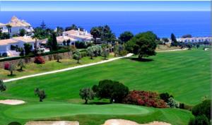 马尼尔瓦APARTAMENTOS LOS HIDALGO GOLF的一座以海洋为背景的高尔夫球场