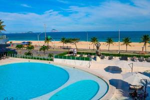 里约热内卢Hotel Nacional Vista Mar c/ Banheira的享有游泳池和海滩的景色