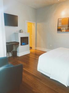 圣克鲁兹太平洋之蓝旅馆的卧室配有白色的床和壁炉