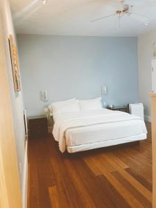 圣克鲁兹太平洋之蓝旅馆的卧室配有白色的床,铺有木地板
