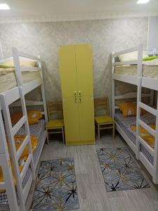 久姆里Aragats Hostel & Guest House的客房设有三张双层床和黄色橱柜。