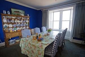 布鲁莱迪Loch Gorm House的一间带桌椅和窗户的用餐室