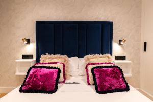 布埃乌Apartamento Illa do Santo的一张带粉红色枕头和蓝色床头板的床