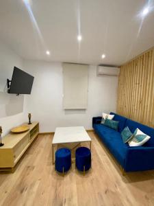 哈恩Apartamento boutique Jaén 2的客厅配有蓝色的沙发和桌子