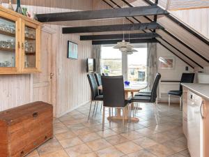 Nørre Lyngvig8 person holiday home in Ringk bing的厨房以及带桌椅的用餐室。
