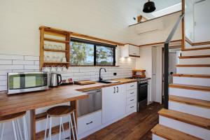 伊登Boydtown Beach Holiday Park的厨房配有白色橱柜和木制台面