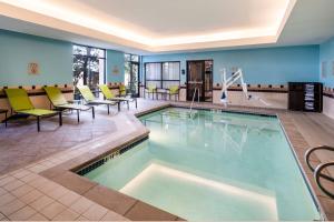 科罗拉多斯普林斯科罗拉多斯普林斯南万豪春季山丘套房酒店的酒店大堂的游泳池,配有桌椅
