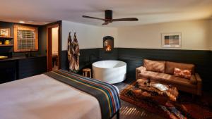 盖尔南维尔Highlands Resort - Adults Only的一间卧室配有一张床、一个浴缸和一张沙发