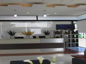达沃市达沃市苏莫亚洲酒店的一间带长凳和电视的客厅