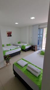 巴亚索拉诺Ecohotel Linda Judith的配有4张带绿色床单的床的客房