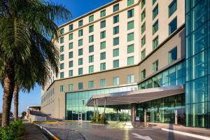 巴拿马城Marriott Panama Hotel - Albrook的一座大建筑,前面有棕榈树