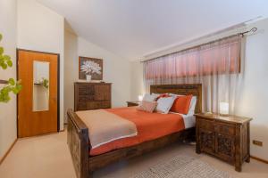 WoodfordGrey Gum Lodge的一间卧室配有一张带橙色毯子的大床