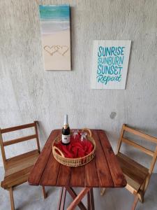 ChuburnáPuerto del Cielo的一张桌子,上面放着一瓶葡萄酒和一篮玫瑰