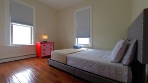 ParkchesterEl Edén的一间卧室配有一张带红色梳妆台的床和两个窗户