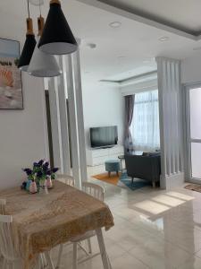 芽庄Ocean Dream Apartment Nha Trang的客厅配有桌子和沙发