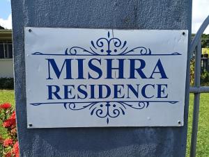 苏瓦Mishra Residence的墙上的米特里亚住宅标志