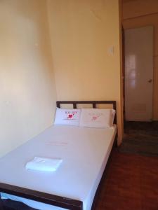 曼达维市WJV INN Mandaue Centro的一张位于房间的床,上面有两个白色枕头
