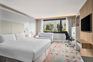 新加坡新加坡凱煌大酒店的酒店客房,配有床和电视