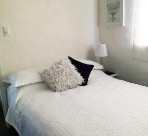 珀斯Kenata-Fairway Apartment Hotel的白色的床和黑白枕头
