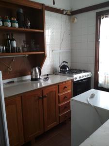 埃斯特角城Verano的厨房配有木制橱柜和炉灶烤箱。