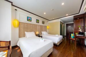 河内Babylon Grand Hotel & Spa的酒店客房配有两张床和一张书桌