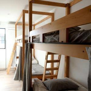 高崎Matoi Hostel & Bar的双层床间设有两张双层床和梯子