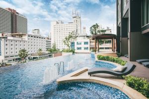 曼谷The Rich Residence Sukhumvit Nana的一座位于城市中心,拥有建筑物的游泳池