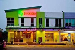士姑来Eight Days Boutique Hotel - Impian Emas的一座绿色和黄色的建筑,设有餐厅
