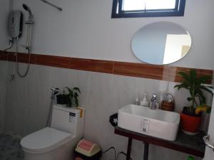 金边可尔之家民宿的一间带卫生间、水槽和镜子的浴室