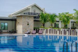 棉兰Grand City Hall Hotel & Serviced Residences的一座带游泳池的度假村,位于一座建筑前