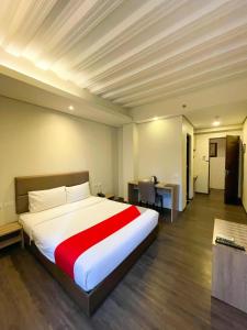 马尼拉Airo Hotel Manila的卧室配有一张大白色床和红色毯子