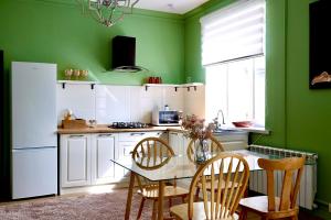 KaynazarkaBerry House close to Talgar Almaty的厨房设有绿色的墙壁和桌椅