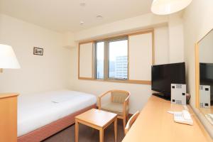 奈良奈良微笑酒店的酒店客房配有一张床和一张带电脑的书桌