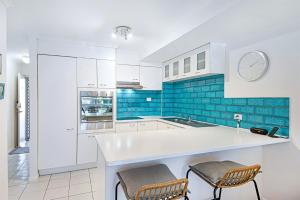 库鲁姆海滩Unit 2 Coolum Terraces的厨房配有白色橱柜和蓝色瓷砖