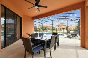 达文波特Large family friendly Vacation Home, Private Pool, Golf course location, Nr Orlando Disney Parks Florida的一间带桌椅的用餐室和一个游泳池