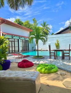 阿鲁甘湾Artist Village的一个带游泳池和桌椅的度假村