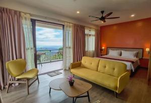 哥打京那巴鲁科科尔避风港度假村的一间卧室配有一张床和一张沙发,并设有一个阳台