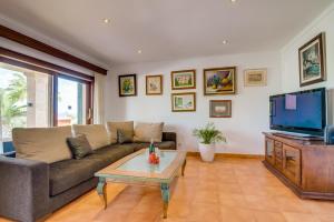阿尔库迪亚Ideal Property Mallorca - Ca na Siona 6 PAX的带沙发和电视的客厅