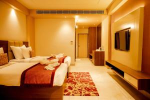 RourkelaHOTEL PAHADI的酒店客房设有两张床和一台平面电视。