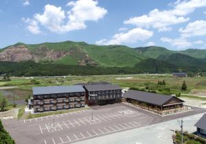 阿苏市Aso Hakuun Sanso的享有建筑的空中景观,以群山为背景