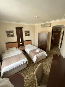 伊斯坦布尔托普卡帕酒店的酒店客房,配有两张床和椅子