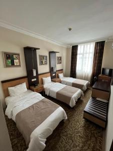 伊斯坦布尔托普卡帕酒店的酒店客房设有三张床和一张书桌
