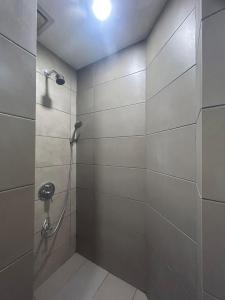 山打根The Elopura Hotel的一间带淋浴的浴室和瓷砖墙