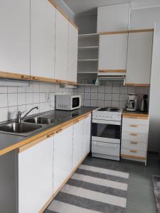 LepaaLepaan Kartanon Toimela的厨房配有白色橱柜和水槽
