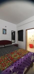 蒙纳Durga budget stay的一间卧室配有一张带五颜六色棉被的床