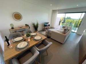 卡巴纳斯·德·塔维拉Ocean View Top Luxury New Built T1 -WPOV1的客厅配有桌椅和沙发