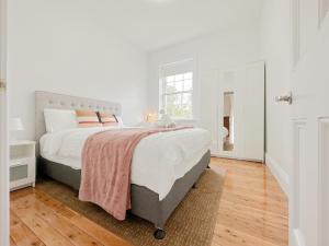 悉尼Kent Cosy House的白色的卧室设有一张大床和一个窗户