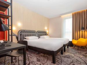 什切青ibis Styles Szczecin Stare Miasto的酒店客房配有两张床和一张书桌