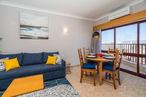 波尔蒂芒Praia Mar - Apartamento Viva Local的客厅配有蓝色的沙发和桌椅